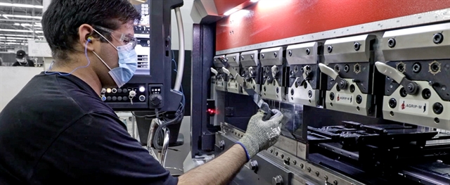 A man adjusting a machine during manufacturing at Tempco