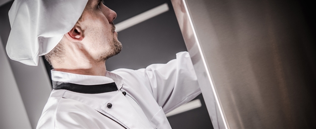 Chef looking into industrial refrigerator