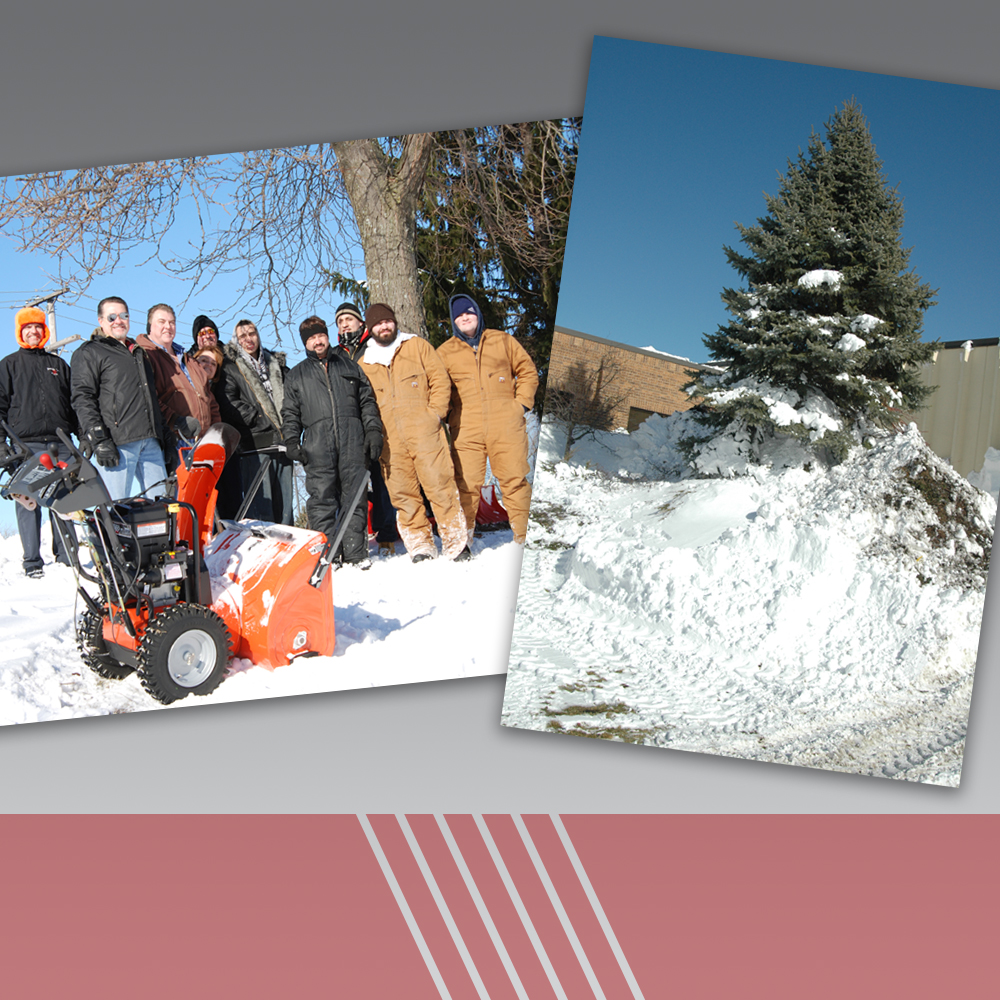 group of people in the snow, snow piles high near the buliding and a tree